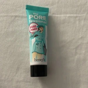 Benefit The POREfessional Primer - The POREfessional Primer från Benefit i en turkos tub med svart lock. Denna primer minimerar synliga porer och ger en silkeslen finish. Tuben rymmer 7,5 ml och har en cool retrodesign med illustration av en kvinna i trenchcoat.