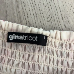 Rosa blommig volangkjol Gina Tricot - Supersöt kort kjol från Gina Tricot i rosa och vitt med blommigt mönster. Storlek S men sitter som en XS. Inga slitage, ser ut att vara helt ny