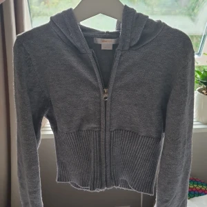 Grå stickad hoodie från Gina Tricot - Mysig grå hoodie från Gina Tricot med dragkedja framtill och huva🩷Tröjan är stickad med bred ribbad kant nedtill och vid ärmsluten, vilket ger en snygg och trendig look. Super skönt material och bara använt cirka 5 gånger🩷