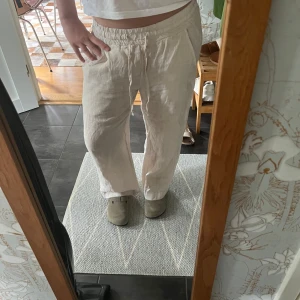 Beiga linnebyxor med snörning - Säljer ett par beiga linnebyxor från Chelsea med avslappnad passform och resår i midjan. Byxorna har snörning framtill och raka, lite vidare ben. Använt fåtal gånger men inget som syns på varan. Passar mig PERFEKT som är 156 cm🩷