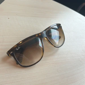 Ray-Ban Boyfridend  - Snygga solglasögon från Ray-Ban i en klassisk wayfarer-stil. De har en brun leopardmönstrad båge och tonade glas. Perfekta för att ge en cool touch till din stil.