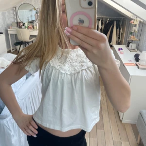 Vit Zara topp🩷 - Säljer en söt vit blus med korta ärmar och vacker spetsdetalj runt halsen. Perfekt för en somrig look eller en avslappnad dag. Blusen har en lös passform som ger en bekväm känsla.💕💕💕💕