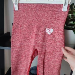 Röda Womens Best Leggings i storlek XS  - Röd melerade leggings från Women's Best. Storlek XS. Väldigt stretchiga. Leggingsen är nya utan lapp men när tråd har dragits i grenen. Inget hål eller så. I övrigt i jättefin skick. Loggorna intakta.