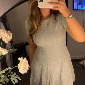 Grå kortklänning - Säljer en grå kortklänning med rund hals. Klänningen har superfina detaljer upptill med pärlor 💌 klänningen är i ett superskönt material. Passar M/S storleksmässigt. 