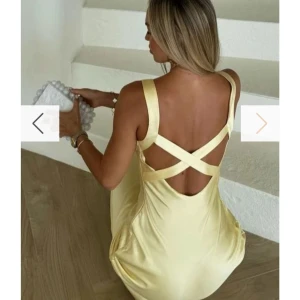 andie anderson klänning - Elegant gul långklänning i satin med korsade band i ryggen. Klänningen har en v-ringad design och är ärmlös, vilket ger en stilren och somrig look. Perfekt till balen!⭐️priset går att diskutera vid snabbt köp!