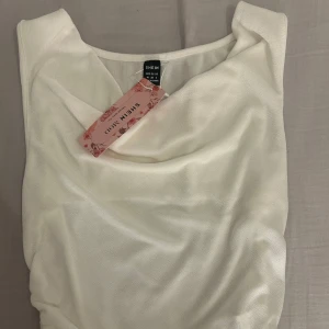 Vit topp från Shein - Säljer en stilren vit topp från Shein. Toppen har en superfin urringning och är i ett väldigt svalt material, säljer då de inte riktigt passar min stil därav är den aldrig använd 