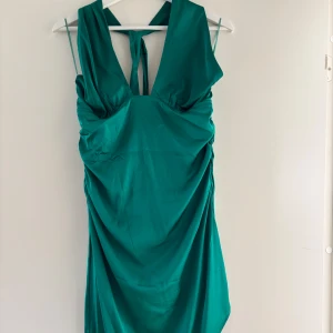 Grön klänning - Snygg grön klänning från NLY EVE med knytband i ryggen och smala axelband. 