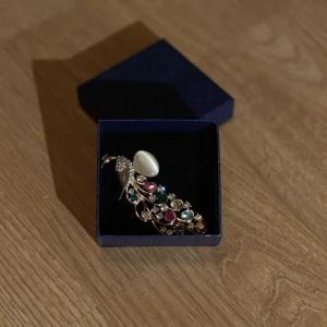 Färgglad brosch i form av en fågel - Elegant glamor brosch i form av en påfågel? Perfekt som en iögonfallande accessoar. Aldrig använt, glittrig och fin 💖