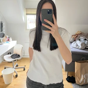 Vit kortärmad tröja - Säljer en stilren vit tröja med korta ärmar och ribbad nederkant. 