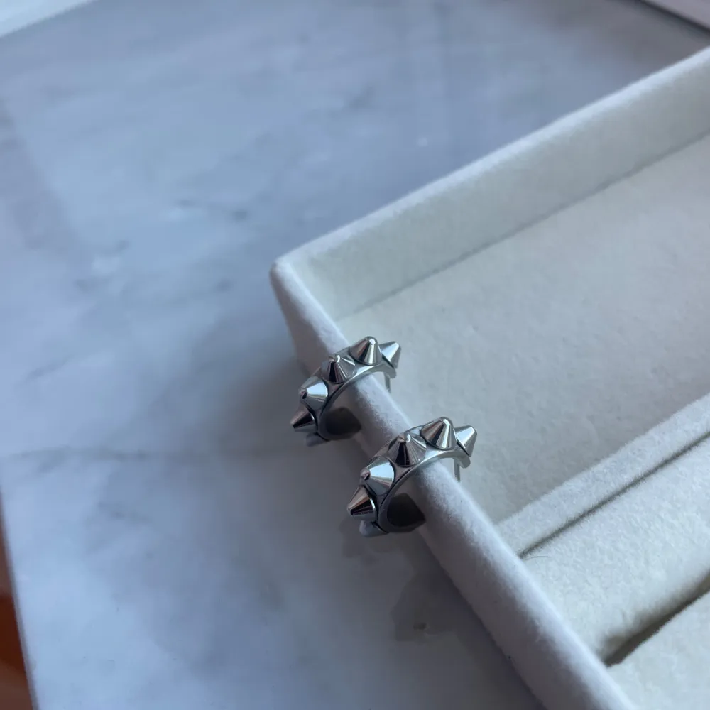 Säljer dessa jättesnygga silvriga örhängena från Edblad. Perfekta för att ge en edgy touch till din stil. De är lätta att bära och passar till många olika outfits. Säljer för jag inte bär silver smycken, inga defekter!😊🌸 pris kan diskuteras!. Asusteet.