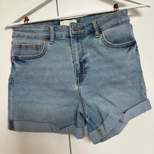 Blå jeansshorts från H&M - Snygga blå jeansshorts från H&M i storlek 36/S, säljer då de inte används.                         Midjemått rakt över: 35cm                                    Innerbensmått: 8cm                                                Hela benet: 32cm
