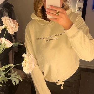 Beige hoodie med tryck - Säljer en beige hoodie med texten 'LA VIE EST FAITE DE PETITS BONHEURS' tryckt på framsidan. Superfin och mysig💌Passar XS storleksmässigt 