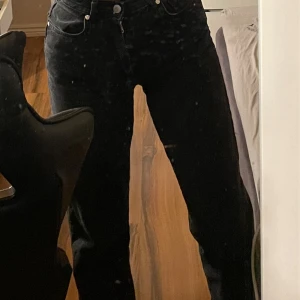 Svarta jeansbyxor - Snygga svarta jeansbyxor med hög midja och rak passform. Perfekta för en stilren look. Klassisk design med knappar och dragkedja framtill. Waist: 25 Length: 32