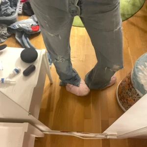 Blå jeans med slitningar - Säljer ett par blå jeans med slitningar på knäna och låren. De har en klassisk femficksdesign och en avslappnad passform. Perfekta för en casual look.