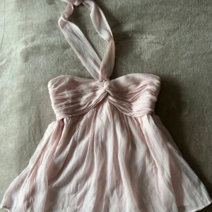 Ljusrosa halterneck topp från Nelly - Säljer en söt ljusrosa halterneck topp från Nelly. Endast använd ett fåtal gånger, så den är som ny :)