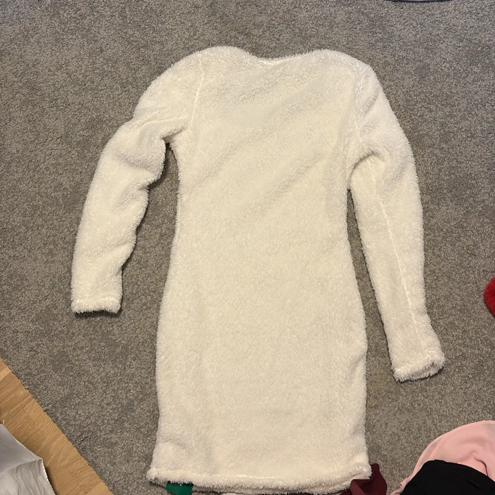 Säljer en supermjuk och fluffig vit klänning från Shein. Klänningen har långa ärmar och en tight passform som ger en snygg siluett. Storlek S och endast provad. 🐑✨. Mekot.