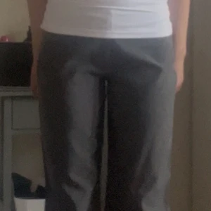 Grå kostymbyxor - Innerbensmåttet: 80 cm (dem är uppsydda så det går att få ca 5 cm extra, se sista bilden.                                                 Midjemått: 37,5 cm.                                 Snygga grå kostymbyxor med en klassisk rak passform. Perfekta för en stilren look. Byxorna har en hög midja och är tillverkade i ett bekvämt material som ger en elegant känsla.
