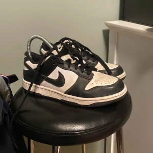 Nike Dunk i svart och vit - Säljer ett par klassiska Nike Dunk sneakers i svart och vit. Skorna har en stilren design med snörning och rund tå. Perfekta för en casual look. Tyvärr ingen låda eller kvitto.svarar på alla frågor😀
