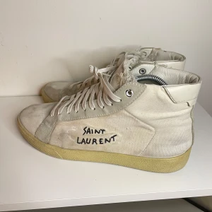 Saint Laurent skor  - Snygga vita sneakers från Saint Laurent i väldigt bra kvalité, de är endast lite smutsiga vilket man kan tvätta bort snabbt så kommer de se ut som nya. Storlek 42 