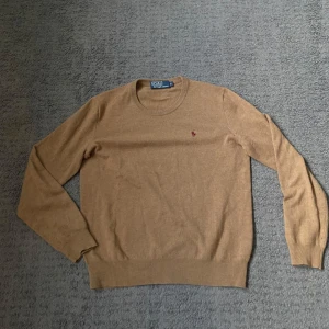 Beige tröja från Polo Ralph Lauren - Säljer en stilren beige tröja från Polo Ralph Lauren i merinoull. Tröjan har en liten broderad logotyp på bröstet och långa ärmar. Perfekt för kyligare dagar. Storlek s använd fåtal gånger ny skick 