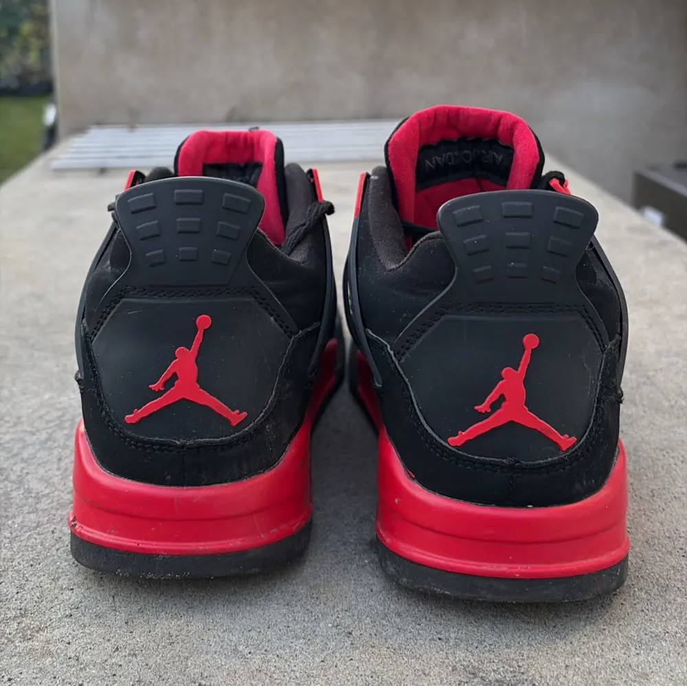 Säljer ett par snygga Nike Air Jordans i svart och rött. Skorna har en ikonisk design med Jumpman-loggan på tungan och hälen. De är tillverkade i mocka med detaljer i syntet och har en bekväm passform med snörning.. Kengät.