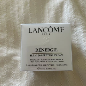  Ny Lancôme Rénergie Peptide Cream 50ml - Lancôme Rénergie H.P.N. 300-Peptide Cream är en lyxig ansiktskräm med hyaluronsyra, 300 peptider och niacinamid. Kommer i en elegant vit och silverfärgad förpackning på 50 ml. Perfekt för dig som vill boosta huden med avancerad anti-age teknologi.