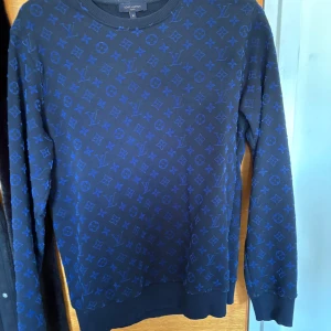 Blå Louis Vuitton tröja Storlek: S - Snygg mörkblå tröja från Louis Vuitton med ikoniskt blått monogrammönster över hela plagget.                                                                               Pris kan diskutera :)