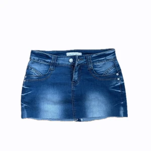 Blå jeanskjol från Miss Yups - Snygg blå jeanskjol från Miss VIP med slitna detaljer och klassiska fickor fram och bak. Kjolen har en kort modell och rå kant nertill för en cool look. Perfekt att matcha med sneakers eller boots.