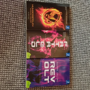 Hungerspelen-trilogin: Hungerspelen, Fatta eld, Revolt -  Här är hela Hungerspelen-trilogin i pocket! Snygga omslag och klimatsmarta utgåvor. Perfekt för dig som gillar action, starka karaktärer och episka äventyr. En modern klassiker för unga vuxna. Böckerna var köpa som present men aldrigt använda/lästa. Inga sträckor på ryggen. 