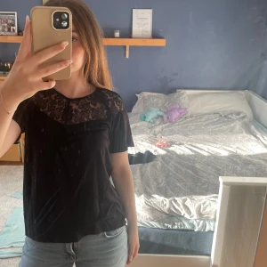 Svart blus med spetsdetalj - Svart blus med korta ärmar och snygg spets upptill både fram och bak.  Bara skriva för fler bilder eller om ni undrar något 💕 den är endast använd ett par gånger. 