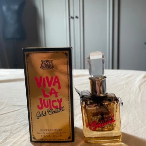 Juicy Couture Viva La Juicy Gold Couture - Juicy Couture Viva La Juicy Gold Couture EdP 30 ml. Flaskan är fyrkantig i guldtonat glas med en stor, kristalliknande kork och dekorerad med svart spetsrosett. Framsidan har en guldig emblem och rosa text. Noter av läckra bär och lyxig, gyllene ambra och smällt karamell.