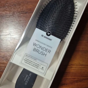 HH Simonsen Wonder Brush svart - En svart Wonder Brush från HH Simonsen med mjuka, flexibla borst och stora runda toppar som masserar hårbotten. Borsten är oval och tillverkad i plast, perfekt för att reda ut håret utan att slita. Snygg dansk design och levereras i originalförpackning.
