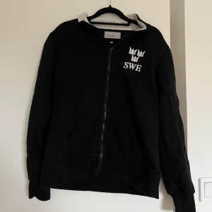 Svart zipjacka Rosetti SWE Horse - Svart zipjacka från Rosetti med vita detaljer.