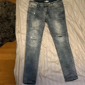 Jeans me slitning - Säljer ett par tvär feta jeans me slitningar på bägge ben. Jeansen har storlek 32/32 och är slimfit. Riktiga trendiga och feta. Vid frågor och funderingar är de bara att höra av sig