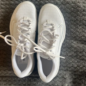 Vita sneakers från Nike - Snygga vita sneakers från Nike med en stilren design. Skorna har en vit sula och snörning för en klassisk look. Helt oanvända o kommer i original förpackning! Nypris 950kr💕