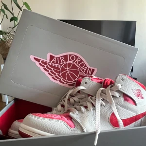 Air Jordan 1 - Säljer ett par riktigt snygga Air Jordan 1 Zoom CMFT 2 ‘Valentine’s Day’ sneakers i vitt och rött. De har en klassisk design med snörning och är utrustade med Zoom Air-dämpning för extra komfort – både stil och funktion i ett!  Endast använda 1 gång och i nyskick. Nypris ca 1100 kr.  Perfekta för dig som vill sticka ut med något unikt! Hör av dig vid frågor eller om du vill se fler bilder.