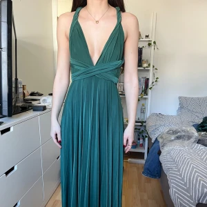 Grön balklänning från GODDIVA - Säljer en elegant grön lång/maxiklänning från GODDIVA men köpt på bubbleroom. Med v-ringad design och öppen rygg. Den går att knytas på flera olika sätt. Perfekt som balklänning eller andra fina tillfällen. Är i storlek xxs men passar även xs. Köpte för några veckor sen och har endast provat den. Lappen sitter kvar. Pris går att diskuteras!