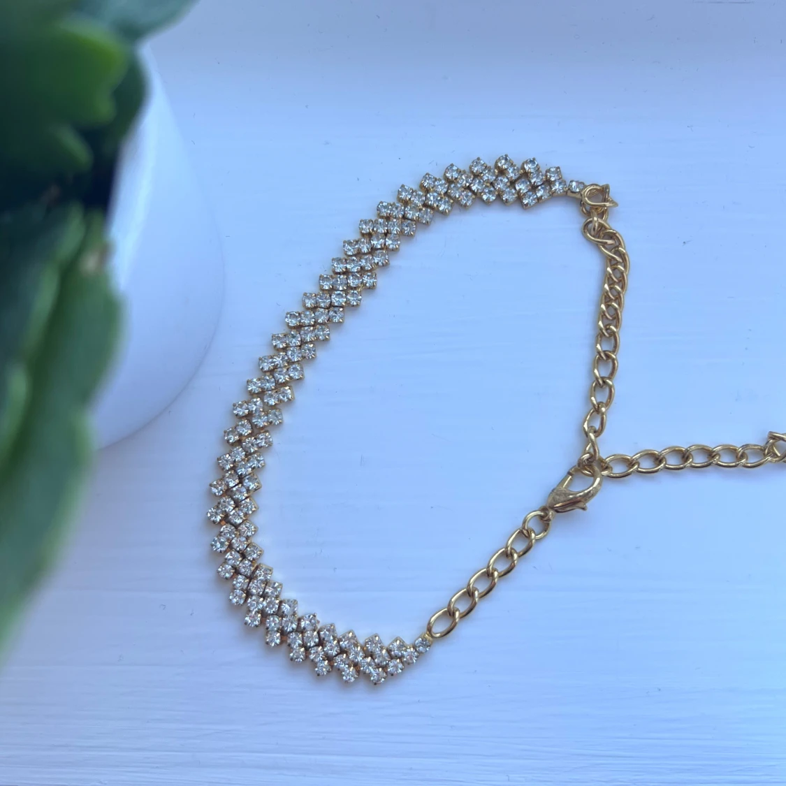 Glittrig fotlänk i guldfärg