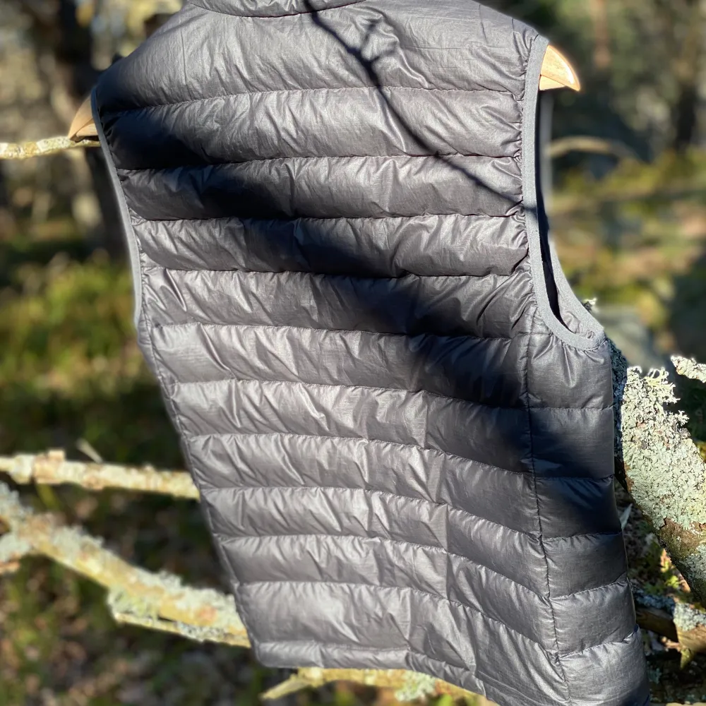 En Patagonia väst i grå färg och storlek XS är verkligen en bra och praktisk plagg! Den är både lätt och varm, perfekt för att ha på sig när det är lite kylligt utomhus. Västen har en stilren design, vilket gör att den passar bra över tröjor eller t-shirts. De 2 pytte små hål på framsida längst ner påverkar inte västens funktion, så du kan fortfarande använda den utan problem! 🌟 Patagonia är också känt för att göra hållbara kläder, så du kan känna dig bra med att bära den. . Takit.