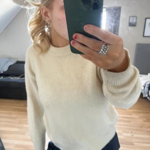 Beige stickad tröja från Gina Tricot - Säljer en mysig beige stickad tröja från Gina Tricot. Tröjan har en klassisk rund hals och långa ärmar med ribbade muddar. Perfekt för kyligare dagar. Lite missfärgningar på ärmarna 