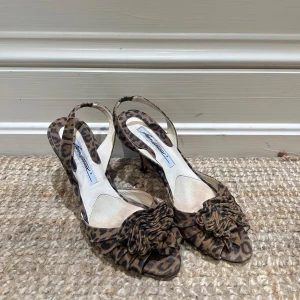 Leopardmönstrade klackar skor med rosett - Snygga leopardmönstrade klackskor med öppen tå och dekorativ rosett framtill. 