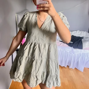 Grön klänning  - Charmig ljusgrön klänning med v-ringning och kort puffärm. 