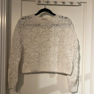 Vit stickad tröja från H&M - Säljer en vit stickad tröja från H&M med ett snyggt mönster. Tröjan har långa ärmar och den är luftig, perfekt för sommaren! 