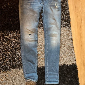 Blå jeans med slitningar Jack Jones  - Snygga blå jeans med slitningar på framsidan för en trendig look. De har en klassisk femficksdesign och en bekväm passform. Perfekta för en avslappnad stil.