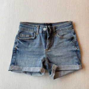 Jeansshorts - Jeansshorts med uppvikta ben från Pieces. Strl XXS. 