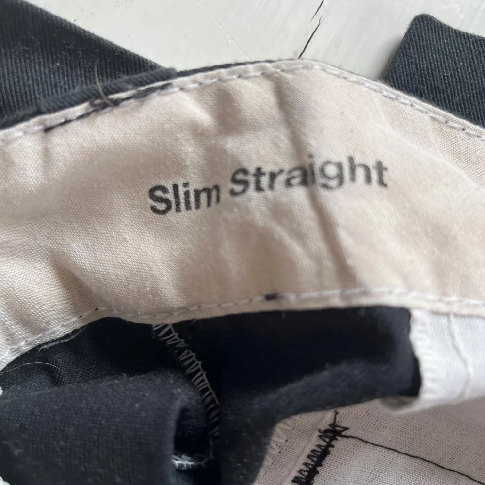 Snygga svarta byxor från Dickies i modellen Slim Straight. Perfekta för en stilren look med en bekväm passform. Byxorna har en klassisk design med fickor och en diskret logga på baksidan. W30 L30. Farkut & Housut.