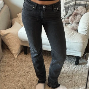 Svarta jeans från Levi's - Snygga svarta jeans från Levi's med klassisk femficksdesign. Low pitch straight. De har en normal passform och är perfekta för en avslappnad stil. Raka med slitning nedtill.