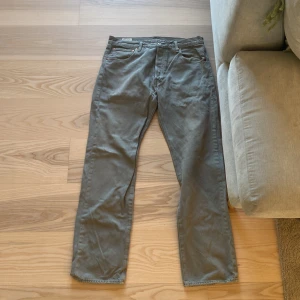 Grå Levis 501 jeans - Säljer ett par klassiska grå Levis 501 jeans. De har en rak passform och är tillverkade i slitstarkt denim. Perfekta för en avslappnad stil.