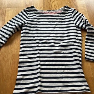 Randig tröja från Bondelid XS - Säljer en stilren randig tröja från Bindeblit i svart och vit. Tröjan har trekvartsärmar och en klassisk design som passar perfekt för både vardag och avslappnade tillfällen. Den är tillverkad i ett mjukt och bekvämt material. Det finns ett pyttelitet hål på insidan av tröjan (se bild). Inget som stör eller syns på utsidan. 