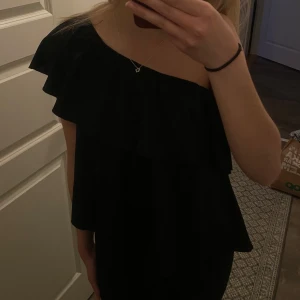 Svart offshoulder topp - Snygg svart offshoulder topp med volangdetaljer. Storlek M men passar även S!